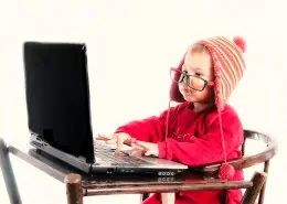 Serious child typing on the laptop computer.Selective focus on the child